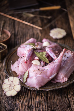 Rabbit. Raw rabbit slices with spices garlic kitchen utensil,fork and butcher. Hunting cuisine.