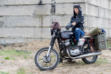 Obraz na płótnie Canvas A post apocalyptic woman on motorcycle near the destroyed building
