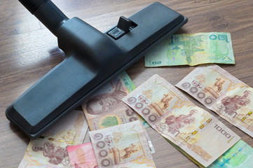 Vacuum cleaner sucks on Thai Banknote