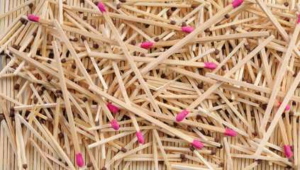 Many matches with brown and rose match heads scattering on rows of matches