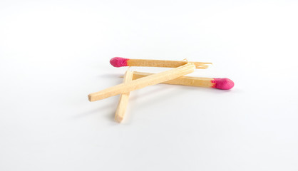 Two broken big matches with rose match head on white background