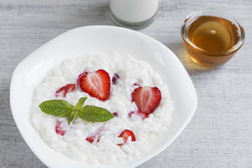 Dairy rice porridge with strawberries in a plate