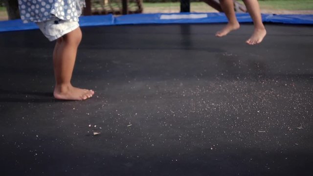 Little child jumping on trampoline in playground