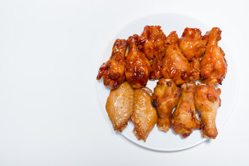Chicken wings with spicy sauce in white plate isolated on white background