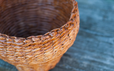Wicker basket on wooden background, side view