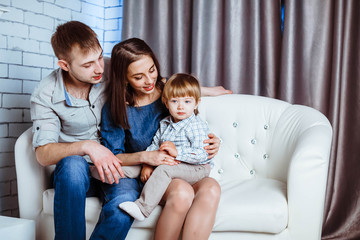 a family with a child sitting on the couch