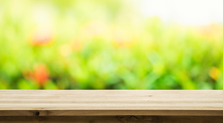 Empty of wood table top on blur of fresh green abstract from garden background.For montage product display or key visual layout