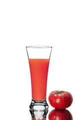 Fresh tomato and a glass of tomato juice, with a mirror image