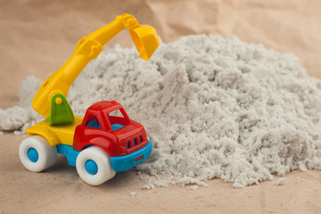 toy backhoe excavator on the playground sand. Construction, mining, construction equipment at work