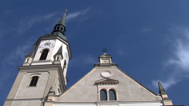 Turm mit Turmuhr der Pfarrkirche Pischelsdorf am Kulm in der Steiermark vor blauem Himmel