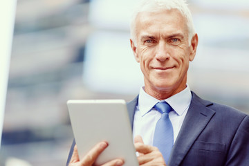 Senior businessman holding touchpad 