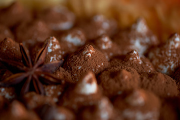 texture of the tops of the tiramisu cake, hats cream sprinkled with cocoa and decorated with star anise