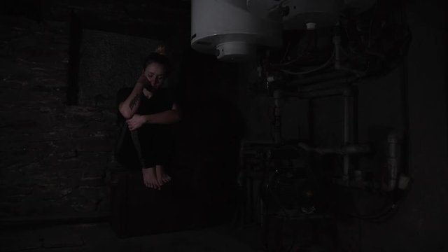 depressed anxious woman sitting in a dark corner of a basement, blinking overhead light