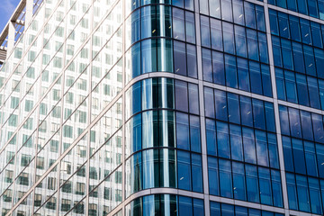 Modern glass exterior of corporate office buildings shot from a low angle.