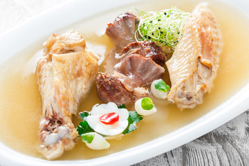 Homemade jelly chicken decorated with greens and eggs on plate on wooden background close up. Cold Meat Dishes