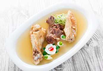 Homemade jelly chicken decorated with greens and eggs on plate on wooden background close up. Cold Meat Dishes