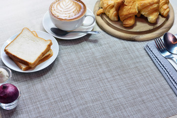 Gray placemat texture have latte art coffee, bread and croissant decorate for background
