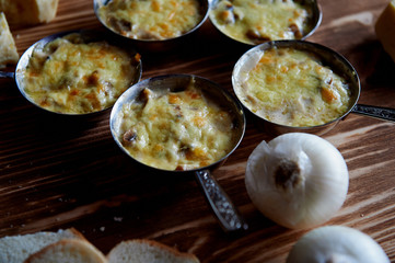 Several zhuleny of mushrooms baked in cream with cheese.In the iron cocotte.