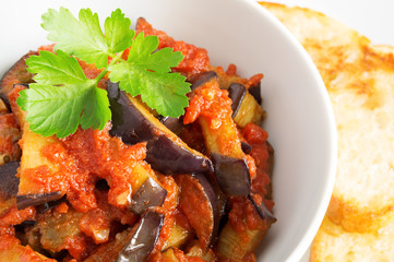 fried eggplant in tomato sauce decorated with parsley leaf