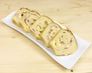 savory cake with salami, ham and cheese on wooden background - top view