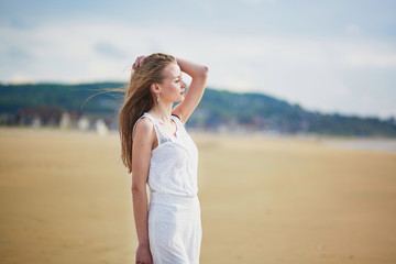 Fototapeta na wymiar Beautiful young woman enjoying sun on a sand beach