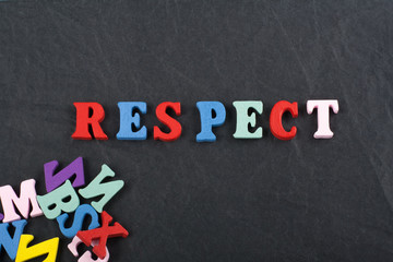 RESPECT word on black board background composed from colorful abc alphabet block wooden letters, copy space for ad text. Learning english concept.