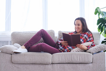 Relaxed lady having rest while reading book