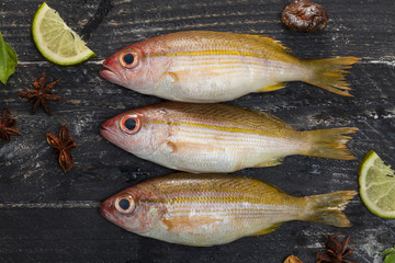 Row of fish on black wooden background,concept cooking background.