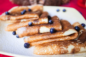 Picture of few pancakes with blackberries and sugar