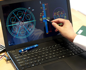 engineer working on computer on mechanical piece design