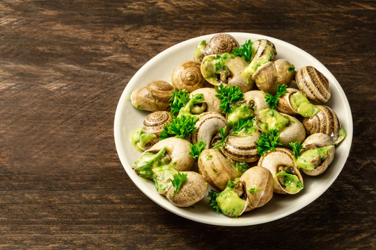 Snails In Green Butter And Herbs Sauce, Typical French Dish
