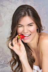 Young girl eating strawberry