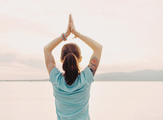 Woman doing yoga on background of sea.