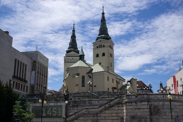 Fototapeta na wymiar Building, Church and town during sunny day with clouds on sky. Slovakia