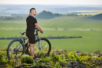 Fototapeta premium Cyclist standing with mountain bike on background of beautiful landscape.