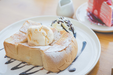 Honey toast with strawberry cake and hot coffee in cozy outdoor cafe.(selective focus, vintage effect)
