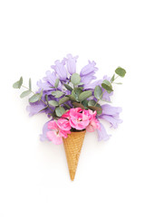 Creative still life . ice cream waffle cone with flowers . Flat lay, top view, copy space