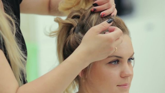 the hairdresser doing hairstyle in beauty salon. Young woman in a beauty salon, beauty