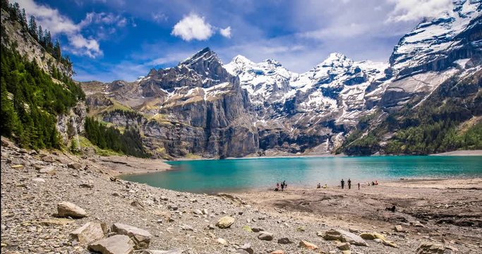 Amazing tourquise Oeschinnensee lake with waterfalls, wooden chalet and Swiss Alps, Berner Oberland, Switzerland. 
