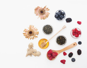 Herbal tea with honey, wild berry and flowers on white background. Flat lay, copy space