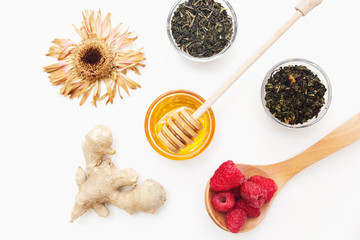 Herbal tea with honey, wild berry and flowers on white background. Flat lay, copy space