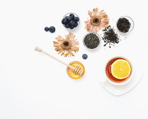 Herbal tea with honey, wild berry and flowers on white background. Flat lay, copy space