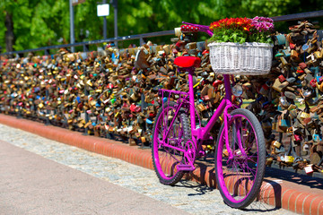 pink bike standing on the bridge of love