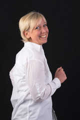 beautiful caucasian mature woman in white shirt, dancing - photograph on black background