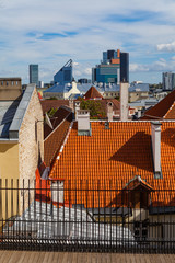 Red tiled roofs of old town and business skyscrapes at the background. Tallinn, Estonia