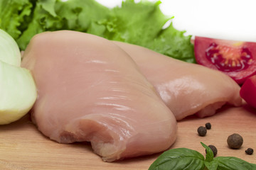 Raw chicken breasts on cutting board