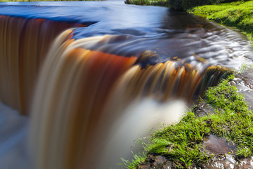 Jagala is the biggest waterfall in Estonia. Long exposure day shot. Close up. Water is red due to swamp organics.