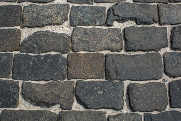 Texture of granite stone blocks with sand between them