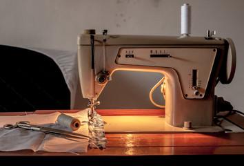 Sewing machine, sewing process, scissors and thread next to machines, pause to replace the thread, fabric is stitched