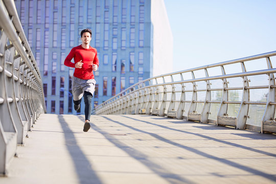 Young Man Running On Bridge